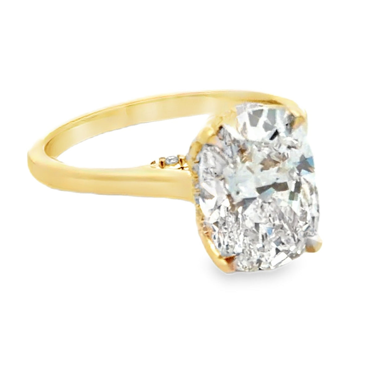 Custom made 14K yellow engagement ring setting with natural diamonds on the bridge and hidden halo totaling 0.10 carat. One center oval lab grown diamond 3.23 carat (E color, VVS2 clarity, IGI report number 762541955)
