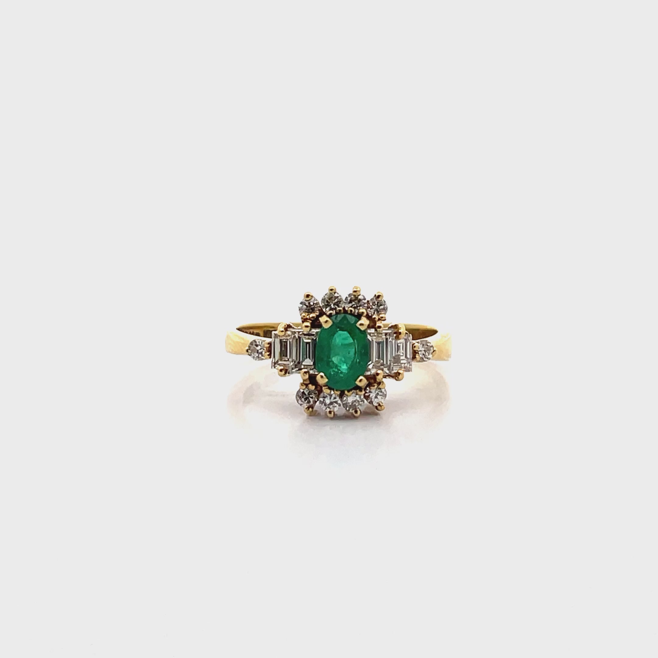 Load video: Vintage Oval Emerald Ring with Round and Baguette Diamonds Set in 18K Yellow Gold